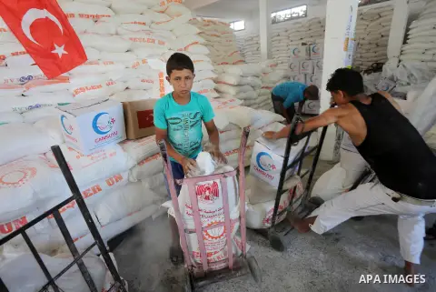 Palestinians receive Turkish aid at an aid distribution centre in Gaza city, on July 19, 2016. The aid, consisting of flour, sugar and rice, was allowed into the Palestinian territory via Israel’s Kerem Shalom crossing a...