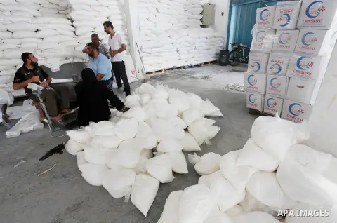 Palestinians receive Turkish aid at an aid distribution centre in Gaza city, on July 19, 2016. The aid, consisting of flour, sugar and rice, was allowed into the Palestinian territory via Israel’s Kerem Shalom crossing a...