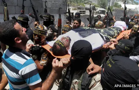 Palestinian members of the Islamic Jihad's armed wing, the Al-Quds Brigades, carry the body of a fellow militant, Salah al-Astal, who died after a tunnel collapse in the Gaza Strip, during his funeral in Khan Younis in t...