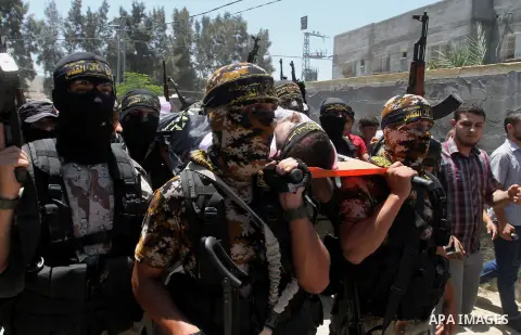Palestinian members of the Islamic Jihad's armed wing, the Al-Quds Brigades, carry the body of a fellow militant, Salah al-Astal, who died after a tunnel collapse in the Gaza Strip, during his funeral in Khan Younis in t...