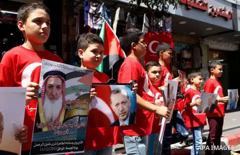 Palestinians hold portraits of Turkish President Recep Tayyip Erdogan during a protest against the military coup attempt in Turkey in the West bank city of Hebron 20 July 2016. Photo by Wisam Hashlamoun