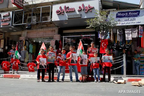 Palestinians hold portraits of Turkish President Recep Tayyip Erdogan during a protest against the military coup attempt in Turkey in the West bank city of Hebron 20 July 2016. Photo by Wisam Hashlamoun
