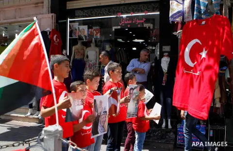 Palestinians hold portraits of Turkish President Recep Tayyip Erdogan during a protest against the military coup attempt in Turkey in the West bank city of Hebron 20 July 2016. Photo by Wisam Hashlamoun