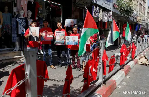Palestinians hold portraits of Turkish President Recep Tayyip Erdogan during a protest against the military coup attempt in Turkey in the West bank city of Hebron 20 July 2016. Photo by Wisam Hashlamoun
