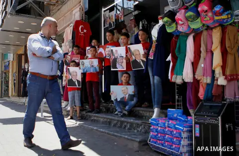 Palestinians hold portraits of Turkish President Recep Tayyip Erdogan during a protest against the military coup attempt in Turkey in the West bank city of Hebron 20 July 2016. Photo by Wisam Hashlamoun
