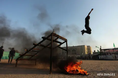 Palestinian youths demonstrate their skills during a military-style exercise at the Liberation Youths summer camp, organised by the Hamas movement, in Gaza city on July 20, 2016. Photo by Ashraf Amra
