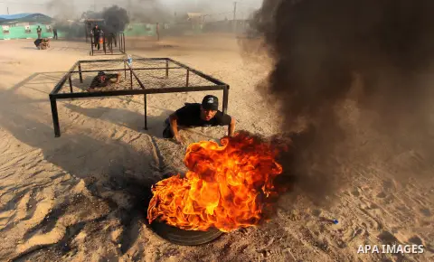 Palestinian youths demonstrate their skills during a military-style exercise at the Liberation Youths summer camp, organised by the Hamas movement, in Gaza city on July 20, 2016. Photo by Ashraf Amra