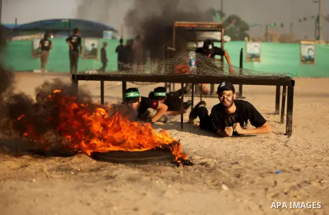 Palestinian youths demonstrate their skills during a military-style exercise at the Liberation Youths summer camp, organised by the Hamas movement, in Gaza city on July 20, 2016. Photo by Ashraf Amra
