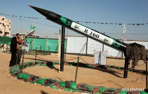 Palestinians stand in front of a rocket during a weapon exhibition at a Hamas-run youth summer camp, in Gaza City, on July 21, 2016. Photo by Ashraf Amra