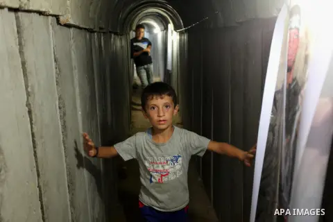 Palestinians walk inside a tunnel used for military exercises during a weapon exhibition at a Hamas-run youth summer camp, in Gaza City, on July 21, 2016. Photo by Ashraf Amra