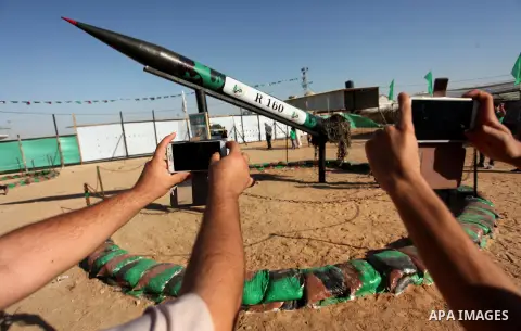 Palestinians take a photo next to a rocket during a weapon exhibition at a Hamas-run youth summer camp, in Gaza City, on July 21, 2016. Photo by Ashraf Amra