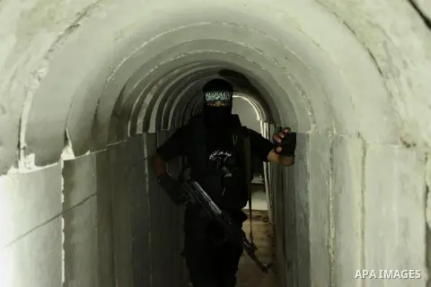 A member of the Ezzedine al-Qassam Brigades, the military wing of the Palestinian Islamist movement Hamas, walks inside a tunnel used for military exercises during a weapon exhibition at a Hamas-run youth summer camp, in...