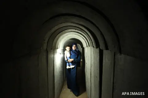 A Palestinian woman walks inside a tunnel used for military exercises during a weapon exhibition at a Hamas-run youth summer camp, in Gaza City, on July 21, 2016. Photo by Ashraf Amra