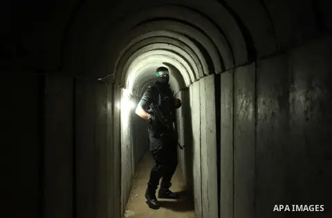 A member of the Ezzedine al-Qassam Brigades, the military wing of the Palestinian Islamist movement Hamas, walks inside a tunnel used for military exercises during a weapon exhibition at a Hamas-run youth summer camp, in...