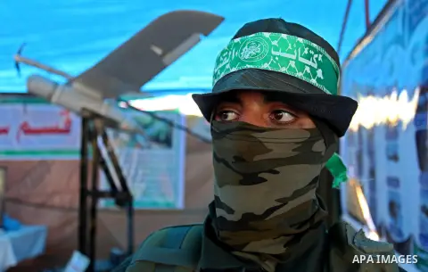 A member of the Ezzedine al-Qassam Brigades, the military wing of the Palestinian Islamist movement Hamas poses for a photographer during a weapon exhibition at a Hamas-run youth summer camp, in Gaza City, on July 21, 20...