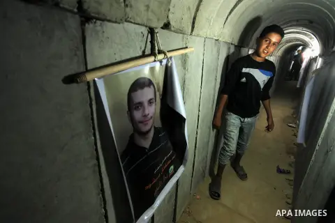 Palestinians walk inside a tunnel used for military exercises during a weapon exhibition at a Hamas-run youth summer camp, in Gaza City, on July 21, 2016. Photo by Ashraf Amra