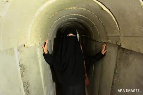 A Palestinian woman walks inside a tunnel used for military exercises during a weapon exhibition at a Hamas-run youth summer camp, in Gaza City, on July 21, 2016. Photo by Ashraf Amra
