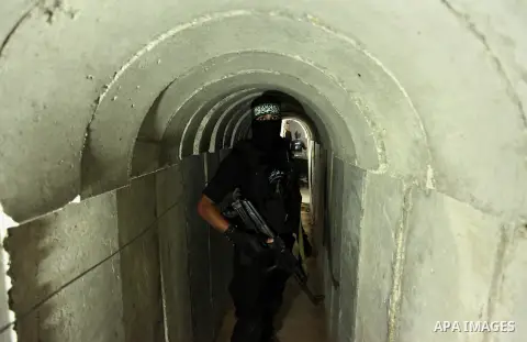 A member of the Ezzedine al-Qassam Brigades, the military wing of the Palestinian Islamist movement Hamas, walks inside a tunnel used for military exercises during a weapon exhibition at a Hamas-run youth summer camp, in...