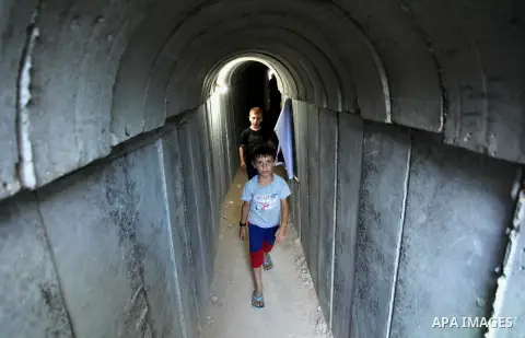 Palestinians walk inside a tunnel used for military exercises during a weapon exhibition at a Hamas-run youth summer camp, in Gaza City, on July 21, 2016. Photo by Ashraf Amra