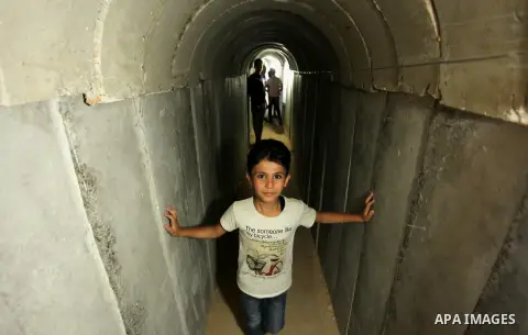 Palestinians walk inside a tunnel used for military exercises during a weapon exhibition at a Hamas-run youth summer camp, in Gaza City, on July 21, 2016. Photo by Ashraf Amra