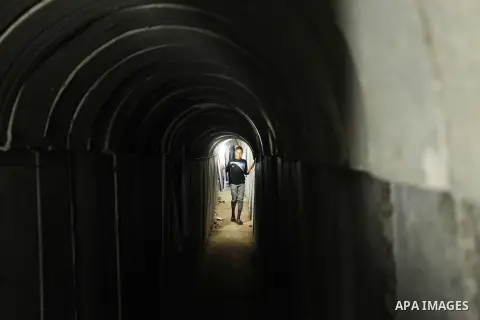 Palestinians walk inside a tunnel used for military exercises during a weapon exhibition at a Hamas-run youth summer camp, in Gaza City, on July 21, 2016. Photo by Ashraf Amra