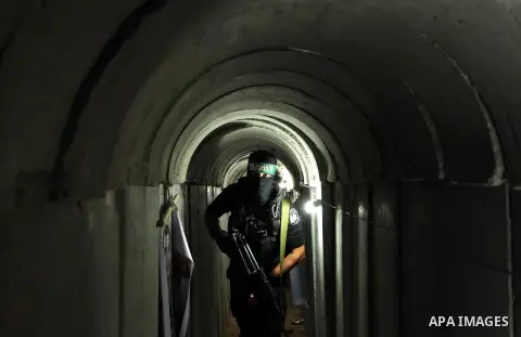 A member of the Ezzedine al-Qassam Brigades, the military wing of the Palestinian Islamist movement Hamas, walks inside a tunnel used for military exercises during a weapon exhibition at a Hamas-run youth summer camp, in...