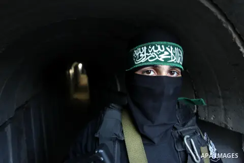 A member of the Ezzedine al-Qassam Brigades, the military wing of the Palestinian Islamist movement Hamas, walks inside a tunnel used for military exercises during a weapon exhibition at a Hamas-run youth summer camp, in...
