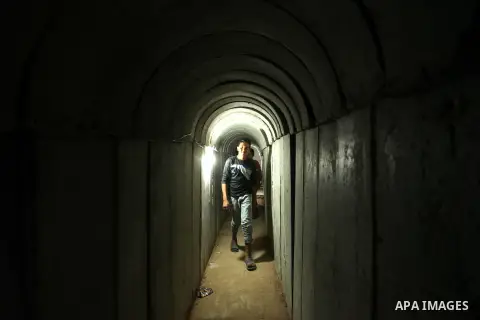 Palestinians walk inside a tunnel used for military exercises during a weapon exhibition at a Hamas-run youth summer camp, in Gaza City, on July 21, 2016. Photo by Ashraf Amra