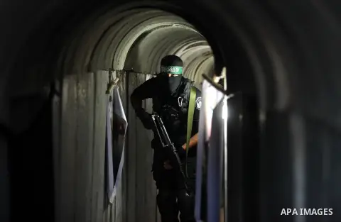A member of the Ezzedine al-Qassam Brigades, the military wing of the Palestinian Islamist movement Hamas, walks inside a tunnel used for military exercises during a weapon exhibition at a Hamas-run youth summer camp, in...