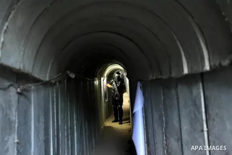 A member of the Ezzedine al-Qassam Brigades, the military wing of the Palestinian Islamist movement Hamas, walks inside a tunnel used for military exercises during a weapon exhibition at a Hamas-run youth summer camp, in...