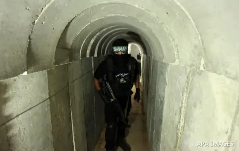 A member of the Ezzedine al-Qassam Brigades, the military wing of the Palestinian Islamist movement Hamas, walks inside a tunnel used for military exercises during a weapon exhibition at a Hamas-run youth summer camp, in...