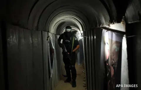 A member of the Ezzedine al-Qassam Brigades, the military wing of the Palestinian Islamist movement Hamas, walks inside a tunnel used for military exercises during a weapon exhibition at a Hamas-run youth summer camp, in...