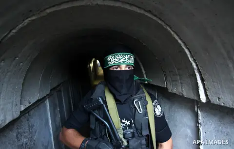 A member of the Ezzedine al-Qassam Brigades, the military wing of the Palestinian Islamist movement Hamas, walks inside a tunnel used for military exercises during a weapon exhibition at a Hamas-run youth summer camp, in...