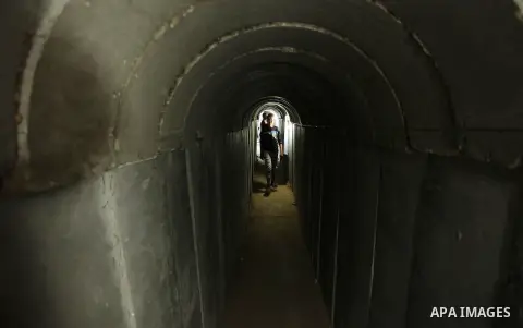 Palestinians walk inside a tunnel used for military exercises during a weapon exhibition at a Hamas-run youth summer camp, in Gaza City, on July 21, 2016. Photo by Ashraf Amra