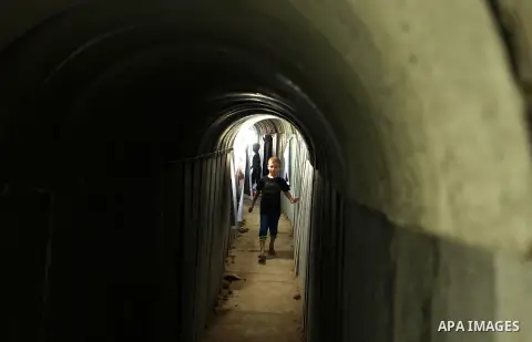 Palestinians walk inside a tunnel used for military exercises during a weapon exhibition at a Hamas-run youth summer camp, in Gaza City, on July 21, 2016. Photo by Ashraf Amra
