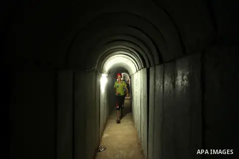 Palestinians walk inside a tunnel used for military exercises during a weapon exhibition at a Hamas-run youth summer camp, in Gaza City, on July 21, 2016. Photo by Ashraf Amra