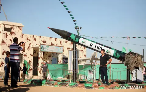 Palestinians take a photo next to a rocket during a weapon exhibition at a Hamas-run youth summer camp, in Gaza City, on July 21, 2016. Photo by Ashraf Amra