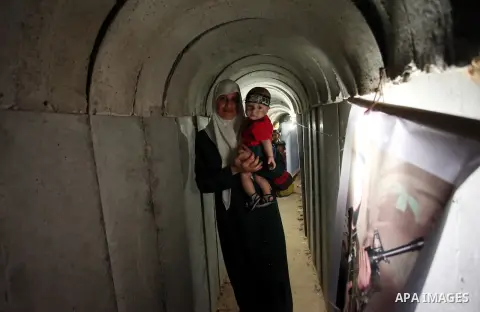A Palestinian woman walks inside a tunnel used for military exercises during a weapon exhibition at a Hamas-run youth summer camp, in Gaza City, on July 21, 2016. Photo by Ashraf Amra