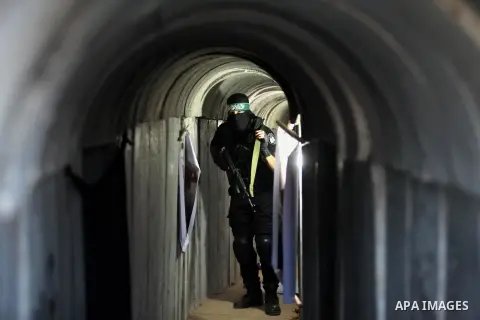 A member of the Ezzedine al-Qassam Brigades, the military wing of the Palestinian Islamist movement Hamas, walks inside a tunnel used for military exercises during a weapon exhibition at a Hamas-run youth summer camp, in...