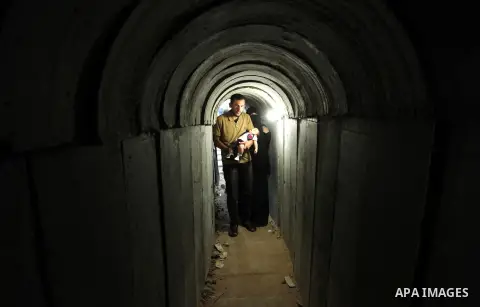 Palestinians walk inside a tunnel used for military exercises during a weapon exhibition at a Hamas-run youth summer camp, in Gaza City, on July 21, 2016. Photo by Ashraf Amra
