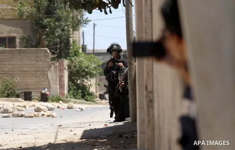 Israeli security forces aim their weapons towards Palestinian protestors during clashes following the weekly demonstration against the expropriation of Palestinian land by Israel in the village of Kfar Qaddum, near Nablu...