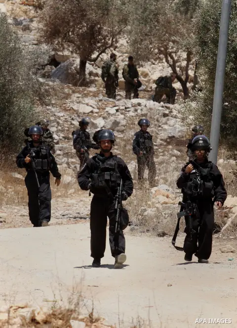 Israeli security forces aim looks towards Palestinian protestors during clashes following the weekly demonstration against the expropriation of Palestinian land by Israel in the village of Kfar Qaddum, near Nablus, in th...