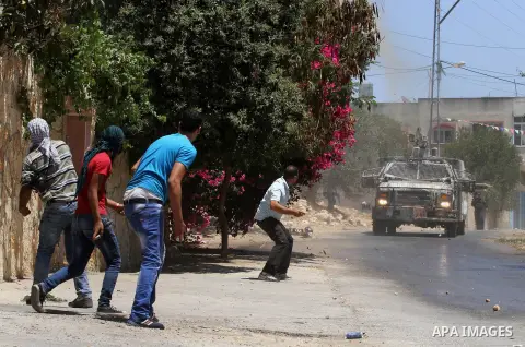 Palestinian protesters throw stones towards Israeli security forces during clashes following the weekly demonstration against the expropriation of Palestinian land by Israel in the village of Kfar Qaddum, near Nablus, in...