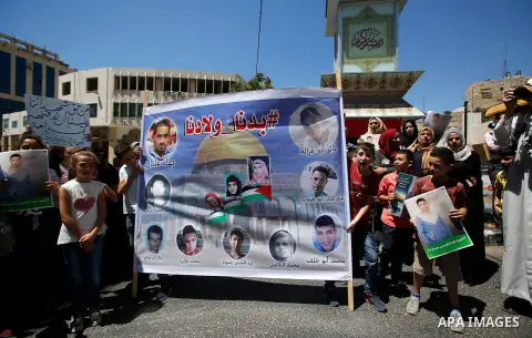Palestinians hold placards during a protest in the West Bank city of Hebron 23 July 2016. Palestinians from all over the West bank held protest to support Palestinians prisoners Bilal Kayyed and Mohammad and Mahmoud Balb...