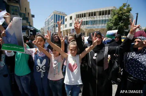 Palestinians hold placards during a protest in the West Bank city of Hebron 23 July 2016. Palestinians from all over the West bank held protest to support Palestinians prisoners Bilal Kayyed and Mohammad and Mahmoud Balb...