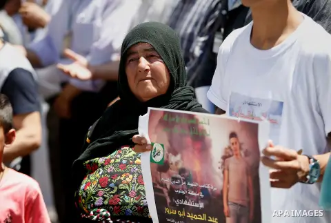 Palestinians hold placards during a protest in the West Bank city of Hebron 23 July 2016. Palestinians from all over the West bank held protest to support Palestinians prisoners Bilal Kayyed and Mohammad and Mahmoud Balb...