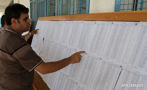 Palestinians look for their names on the registered voters' list at Voter registration centers in Rafah in the southern Gaza strip on July 23, 2016. The Palestinian Central Elections Commission (CEO) announced Saturday t...