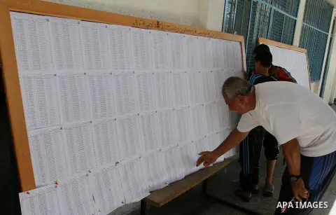 Palestinians look for their names on the registered voters' list at Voter registration centers in Rafah in the southern Gaza strip on July 23, 2016. The Palestinian Central Elections Commission (CEO) announced Saturday t...