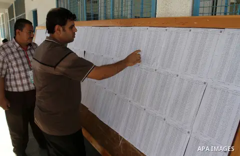 Palestinians look for their names on the registered voters' list at Voter registration centers in Rafah in the southern Gaza strip on July 23, 2016. The Palestinian Central Elections Commission (CEO) announced Saturday t...