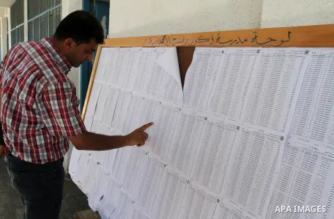 Palestinians look for their names on the registered voters' list at Voter registration centers in Rafah in the southern Gaza strip on July 23, 2016. The Palestinian Central Elections Commission (CEO) announced Saturday t...